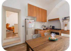 a kitchen with a wooden table and a refrigerator at Rooftop Maisonette - Old Town by TrulloVista in Martina Franca