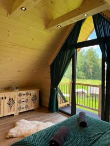 a room with a bed and a large window at Domki góralskie Cisza Leśna in Czerwienne