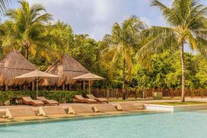 a group of chairs and umbrellas next to a swimming pool at Paradisus by Meliá La Perla - Adults Only - Riviera Maya - All Inclusive in Playa del Carmen
