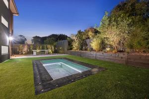 a backyard with a swimming pool in the grass at Casa Lux in Aireys Inlet