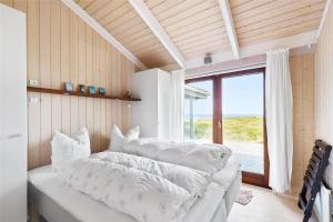 a bedroom with a bed with pillows and a window at 12292-Sjaellands-Odde-Lyngbugten-10 in Yderby