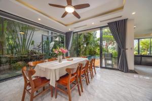 a dining room with a white table and chairs at Luxury Mountain View 3BR Villa Pool 10ppl in Phúc Yên
