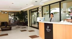 a woman standing behind a counter in a lobby at Bayfront Hotel Subic in Olongapo +53 photos