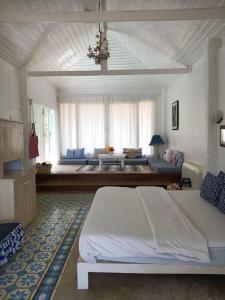 a large bedroom with a bed and a couch at Brassiere Beach Hotel in Baanphakrimlay 