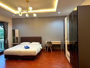 a bedroom with a bed and a desk with a chair at The Horizon Villa Songkhla in Ban Mai