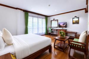 a bedroom with a bed and a living room at Pierre Hotel in Siem Reap