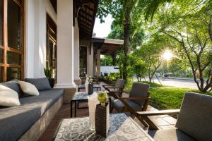 a patio with a couch and chairs on a house at Pierre Hotel in Siem Reap
