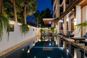 a swimming pool in a villa at night at Pierre Hotel in Siem Reap