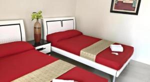 two beds in a small room with red sheets at Sioland Grand Premier Hotel Candelaria in Candelaria +53 photos