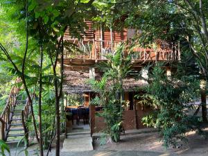 a building with a deck in the middle of trees at Sigiriya Rock Gate Resort in Sigiriya