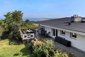 a white house with a deck with a table and chairs at 13317-Asnaes-Mollestraedet-4 in Asnæs
