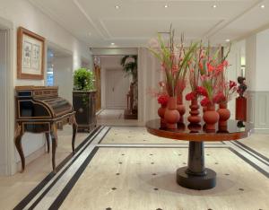 a room with a table with vases of flowers on it at Meliá Paris Vendôme in Paris