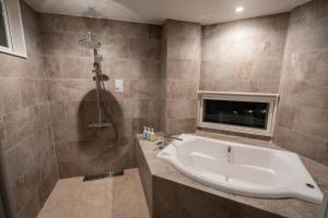 a bathroom with a tub and a shower and a sink at DESLIE - Vacation STAY 74346v in Sarahama