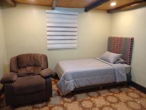 a bedroom with a bed and a chair at Anta lodge in Huaraz