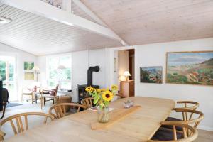 a dining room with a wooden table with flowers on it at 10033-1-Rorvig-Hjortevej-17 in Rørvig