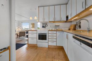 a large kitchen with white cabinets and a table at FJ2401-Skibby-Gogevaenget-31 in Skibby