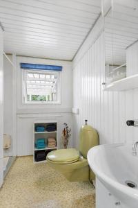 a bathroom with a yellow toilet and a sink at FJ2401-Skibby-Gogevaenget-31 in Skibby +16 photos