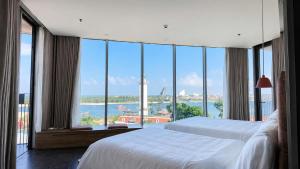 a bedroom with two beds and a view of the ocean at Solia Hill Hotel in Dong Hoi