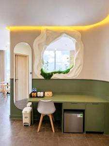 a room with a green desk and a mirror at Solia Hill Hotel in Dong Hoi