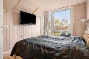 a bedroom with a bed and a flat screen tv at FJ1600-Jaegerspris-Strandleddet-32 in Jægerspris