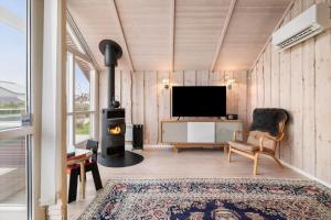 a living room with a television and a fireplace at FJ1600-Jaegerspris-Strandleddet-32 in Jægerspris