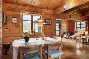 a dining room with a table and chairs in a cabin at FJ4306-Oro-Skovhojgardsvej-3 in Orø