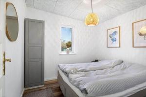 a bedroom with a bed and a mirror and a window at FJ1202-Jaegerspris-Lille-Engvej-7 in Jægerspris