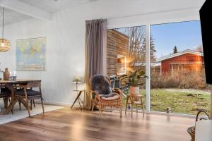 a living room with a table and a large window at FJ1202-Jaegerspris-Lille-Engvej-7 in Jægerspris