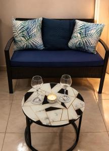 a couch with two wine glasses and a table at Apartament studio Acksen King in Willemstad