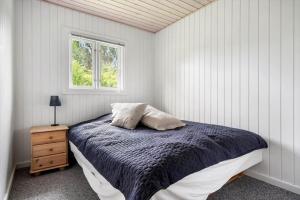a white bedroom with a bed and a window at FJ4307-Oro-Gronnevej-6 in Orø