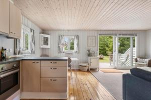 a kitchen and living room with a couch and a table at FJ4307-Oro-Gronnevej-6 in Orø