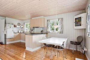 a kitchen with a white table and chairs at FJ4307-Oro-Gronnevej-6 in Orø +19 photos
