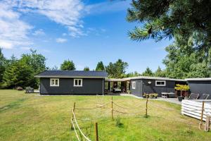 a black house with a fence in a yard at FJ4307-Oro-Gronnevej-6 in Orø