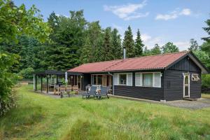a log cabin with a table and chairs in a yard at FJ2002-Skibby-Stormgardsvej-11 in Skibby