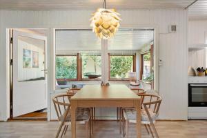 a dining room with a table and a chandelier at FJ1404-Jaegerspris-Strandstien-17 in Jægerspris