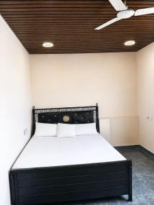 a black bed in a room with a ceiling at Samarth Villa in Akalkot