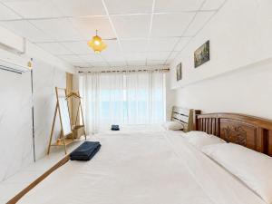 a bedroom with a large white bed in a room at Gao Check in Phala Beach Front in Rayong