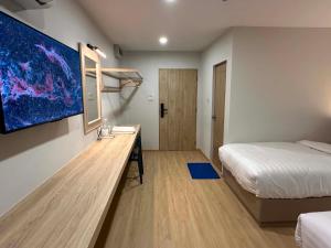 a hotel room with a bed and a desk with a monitor at Tokyo Hotel in Ubon Ratchathani
