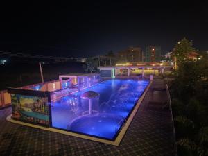 a swimming pool at night with blue lights at Lokenath Resort in Tarapith