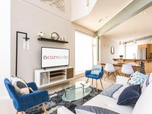 a living room with a white couch and blue chairs at Upscale 3BR Penthouse by CozySuites in Indianapolis +24 photos