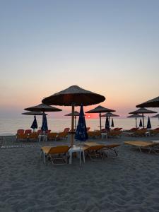 a group of chairs and umbrellas on a beach at Sea view Kastri in Nei Poroi