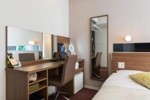 a hotel room with a desk and a bed at Super Hotel Premier Hakataeki in Fukuoka