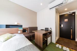 a hotel room with a bed and a desk at Super Hotel Premier Hakataeki in Fukuoka