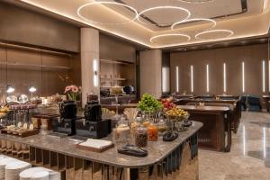 a restaurant with a buffet line with food on a table at Orange Crystal Hotel Kunming Wanda Plaza in Kunming