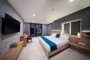 a bedroom with a large bed and a flat screen tv at Harvey's Hotel in Hyderabad