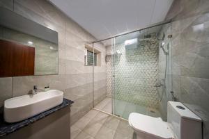 a bathroom with a toilet and a sink and a shower at Harvey's Hotel in Hyderabad