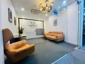 a living room with two couches and a tv at Harvey's Hotel in Hyderabad +12 photos