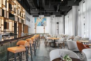 a restaurant with tables and chairs and a bar at Caption By Hyatt Chattanooga Downtown in Chattanooga