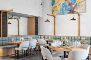 a restaurant with tables and chairs and a painting at Caption By Hyatt Chattanooga Downtown in Chattanooga +14 photos