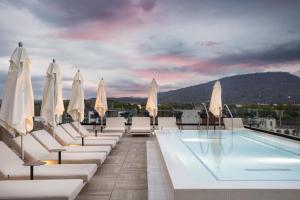 a swimming pool with white lounge chairs and umbrellas at Caption By Hyatt Chattanooga Downtown in Chattanooga